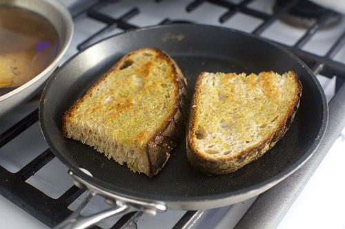 Heat a large skillet over medium-high heat. Add 1 tablespoon olive oil per slice of bread, and cook bread until just golden brown on both sides. Drain on paper towels. 