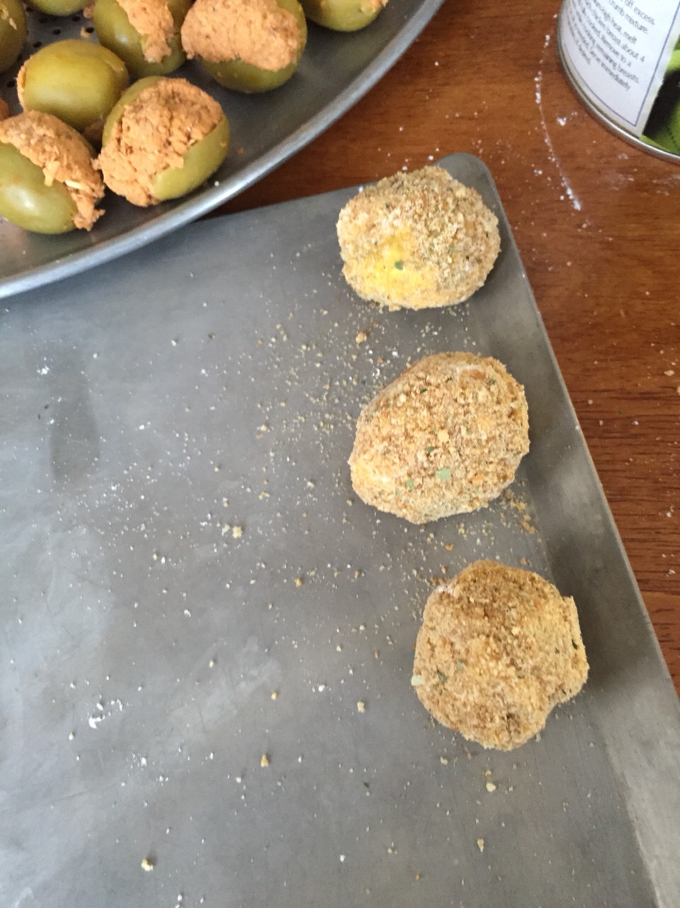 Lay your olives on a tray after they are breaded. 