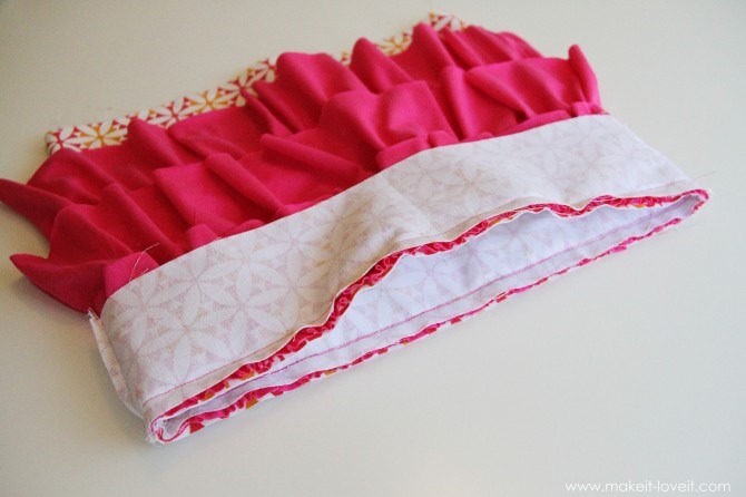 Next, grab the top sections of fabric that were sewn together into a circle (3.5 x 16 inch pieces) and slide it over the ruffled section of fabric, with right sides together.  Match the top edges up evenly, then sew together with a 1/2 inch seam allowance.
