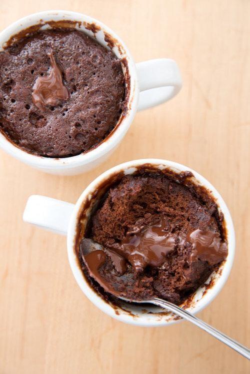 Press 2 chocolate pieces into center of each cake until chocolate is flush with top of cake. Microwave at 50 percent power for 35 seconds (cake should be slightly wet around edges of mug and somewhat drier toward center). Let cakes rest for 2 minutes. 