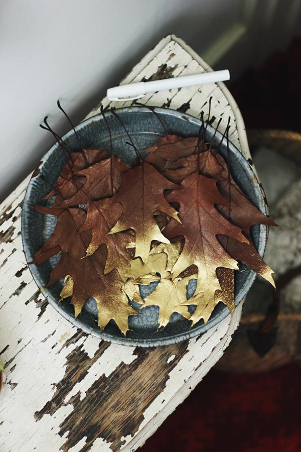 Begin by collecting a bunch of fallen leaves that aren’t too curled up already and press them in a book for a few days. Next up, grab your gold spray paint and carefully spray paint the end/tips of the leaves and let them dry completely.