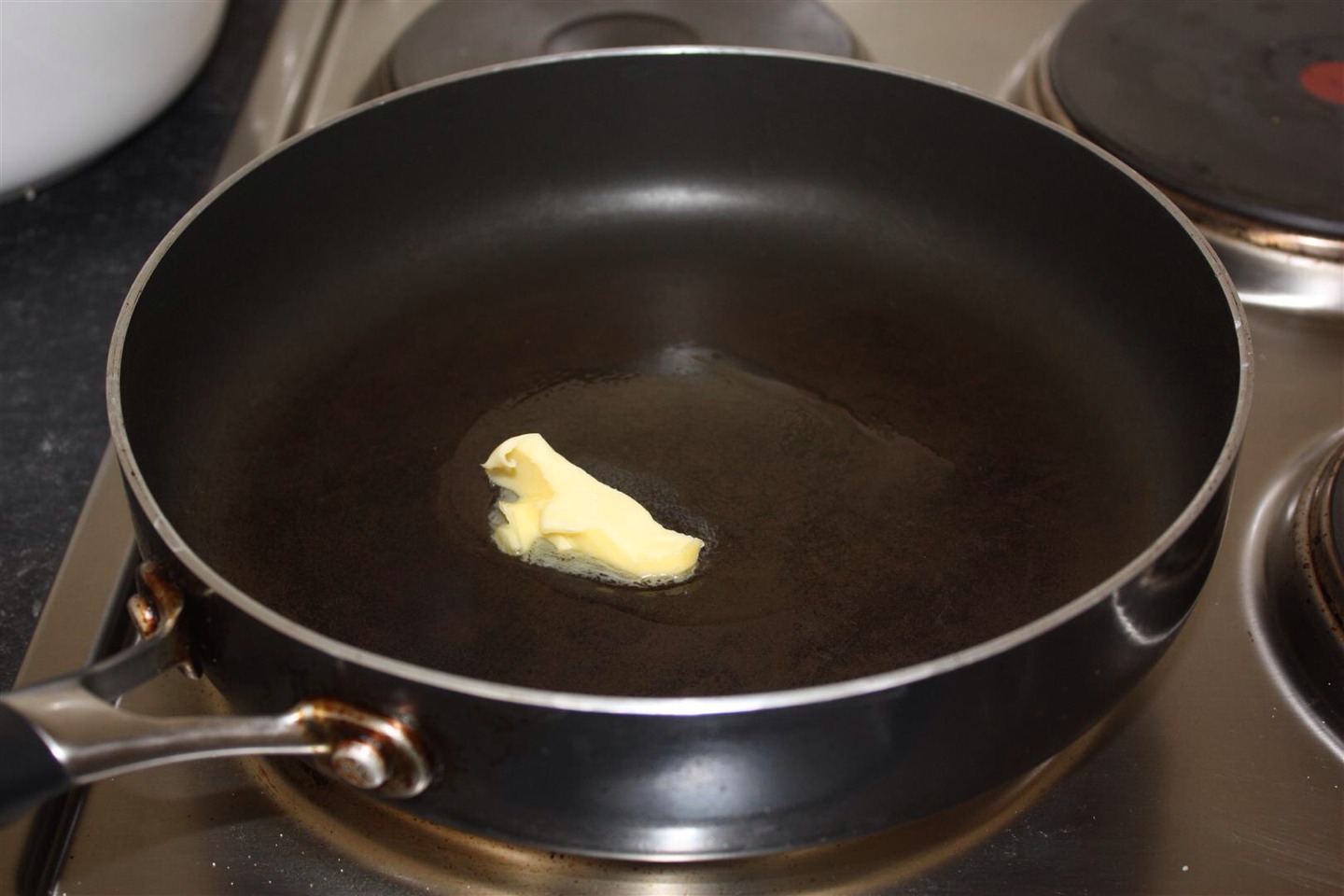 After the crepe batter has chilled, turn the stove to medium heat and place a frying pan with a little butter on the stove.

