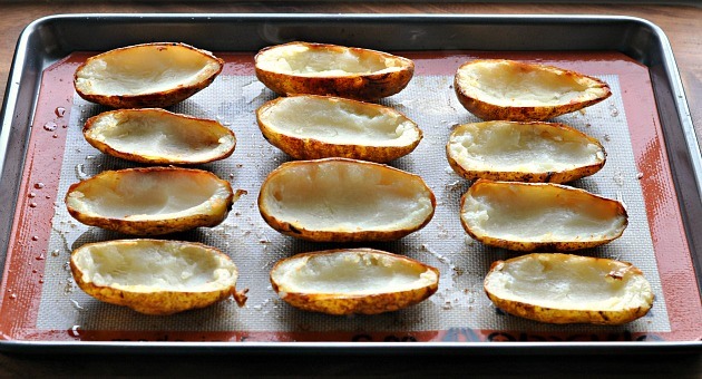 Brush the insides of the potatoes with the melted butter and season with salt and pepper. Flip the potatoes over and do the same to the skins. Evenly separate the potatoes on a baking sheet and broil for 2 to 3 minutes on each side.