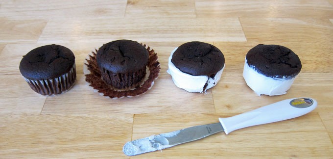 Unwrap the cupcakes and dispose of the paper liners. Frost the sides of each cupcake with Betty Crocker Vanilla frosting. Smooth out the frosting, making each cupcake into a cylinder.