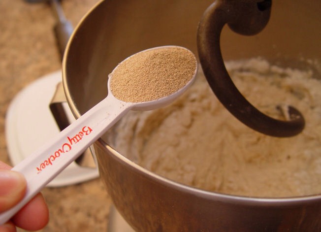 3. Put your milk/butter and hot water in the bottom of your Kitchen Aid Mixer. Add the sugar and salt. Then add 2 C of the flour…let it mix for 1 minute.

4. Add yeast. Turn the mixer on and add the rest of the flour 1 C at a time.
