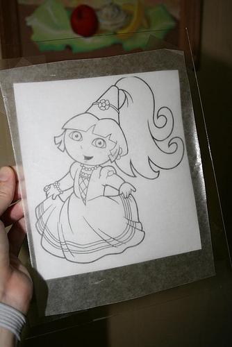 Tape a similarly-sized piece of wax paper to the front of the glass. Now you have a coloring page/glass/wax paper sandwich. 