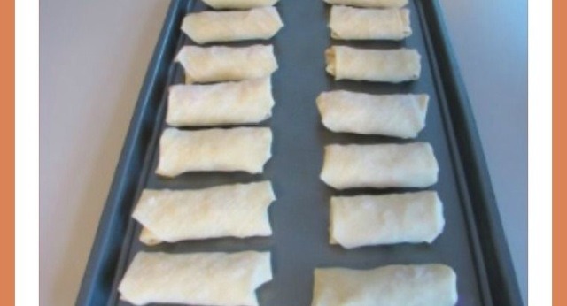 Roll egg rolls, spray a baking sheet with cooking oil, then place and spray the tops of the egg rolls with cooking spray. Preheat oven to 400 degrees and cook for about 10 minutes on each side.