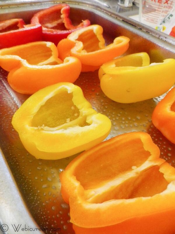 First, spray your baking dish with the olive oil spray. Then wash and halve the peppers lengthwise, removing the white pithy ribs, the stems and the seeds. Line these up in the pan and set aside.