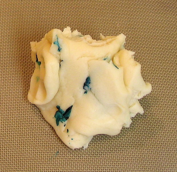 Fold the dough over, working the food color through the body of the playdough, trying to keep the raw dye away from your hands and the counter. You could use gloves or plastic wrap at this stage to keep your hands clean- only the concentrated dye will color your skin