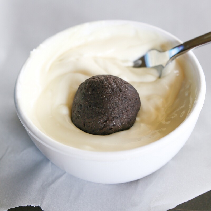 SIXTH STEP:
Take your Oreo balls out of the fridge and dunk them into the melted chocolate. (Your chocolate should've cooled down a bit by now) Lay them neatly on a tray as you go. (Just as you did on the fourth step)