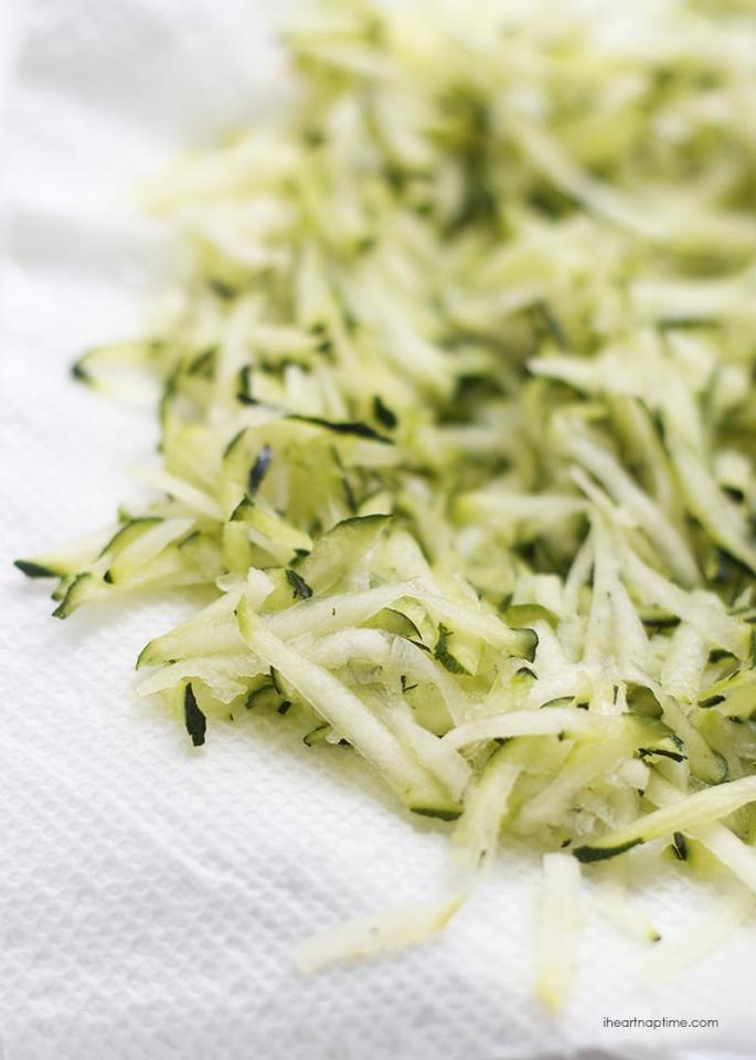 After shredding the zucchini make sure to place it in between two paper towels. This will help soak up any extra water.