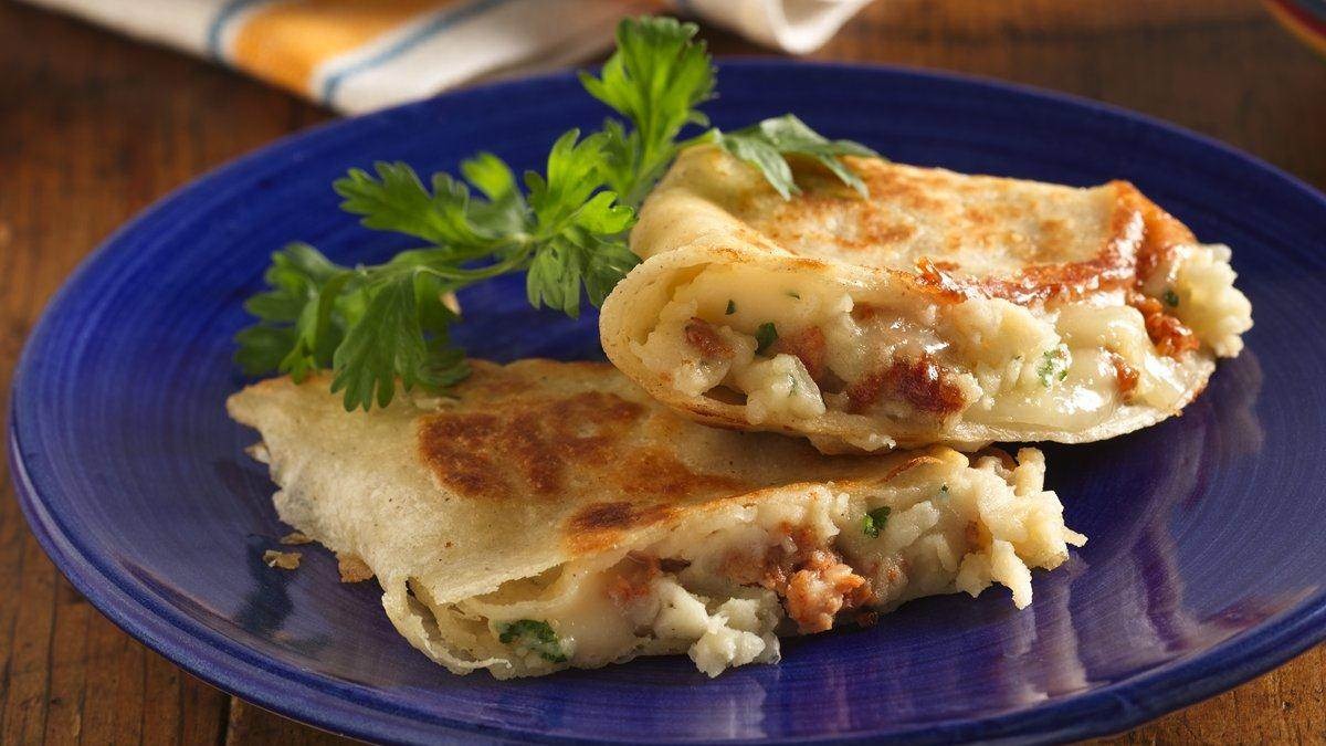Stir together the mashed potatoes, bacon, and green onions. Spread the mashed potato mixture onto one side of half of the tortillas, spreading to within 1/2 inch of the edges. Sprinkle the shredded cheese on top of the mashed potatoes and top with the remaining tortillas.