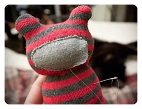 8.Hand sew the edge of the muzzle to the face of your bear. I stitched all across the top, down one side and halfway along the bottom before starting to insert stuffing. Squeeze a bunch into the pocket you created and then continue on stitching to close the rest of it up.