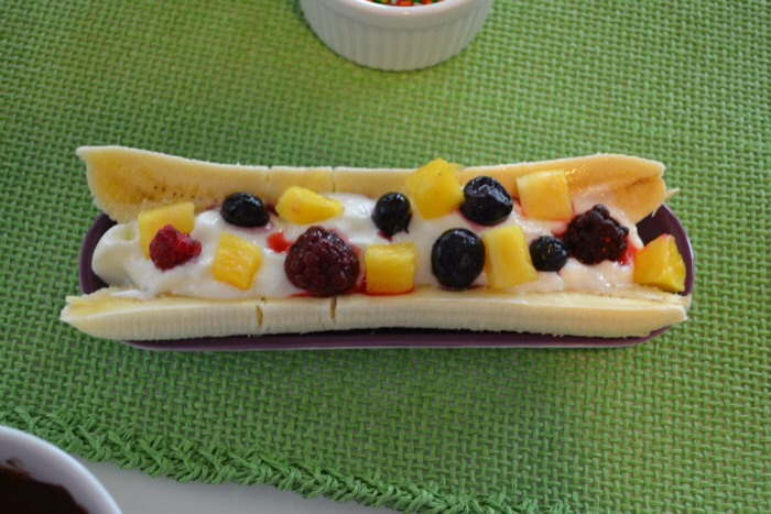 I built the Greek yogurt banana split by slicing the banana and filling it with Greek yogurt and fruit.