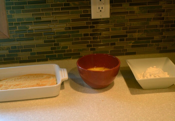 1) Set up your dipping station Instead of using bread crumbs, I pulverize Cornflake cereal in the blender.  I find them to be crispier than breadcrumbs.  I also have 5 eggs in a bowl and flour.

2) Cut your chicken into nugget sized pieces.  AND NO you will not look like McDonalds nuggets:) 
