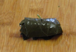 The rolled grape leaf is done. Repeat this procedure with the remaining leaves and the rice filling.
