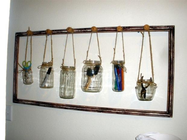 Take a vintage wooden picture frame and hammer nails into the top at equal intervals. Then, dangle mason jars with some twine to hold paintbrushes, scissors, and writing utensils. Can we say hipster?
