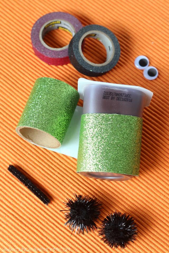 1. Begin by taking the green washi tape and wrapping it around the body of the pudding cup. Depending on the width of the tape, you will need to wrap it around a few times in order to completely cover the plastic. To keep the tape in place I suggest using a few dabs of hot glue.