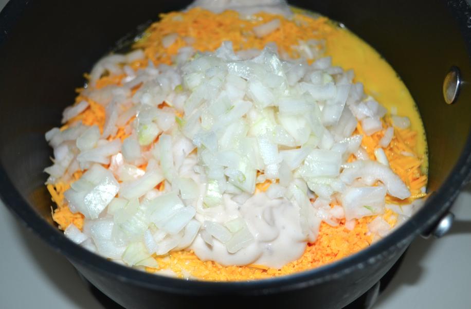 3. Mix mayo, cheddar cheese, eggs, onion and cream of mushroom soup in a large pot. Stir frequently on low heat until well blended.