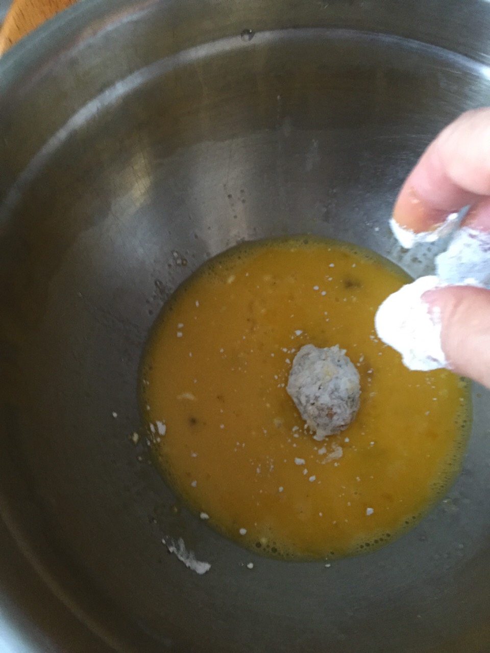 Back into the egg!

After flour it's back into the egg (I use separate egg bowls because the second egg dip from the flour gets thick).  

Make sure you cover the olive in egg again. 