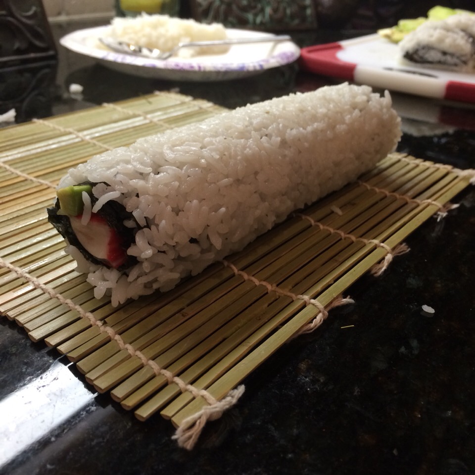 Roll the flat sushi in the board. Use both hands, roll as tight as you can, and don't let the board go inside the sushi roll.