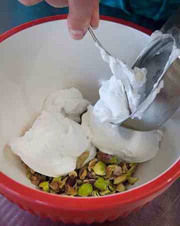 Add ¼ cup shelled and chopped pistachios to a small bowl. Add ¾ cup coconut frosting; stir to combine.