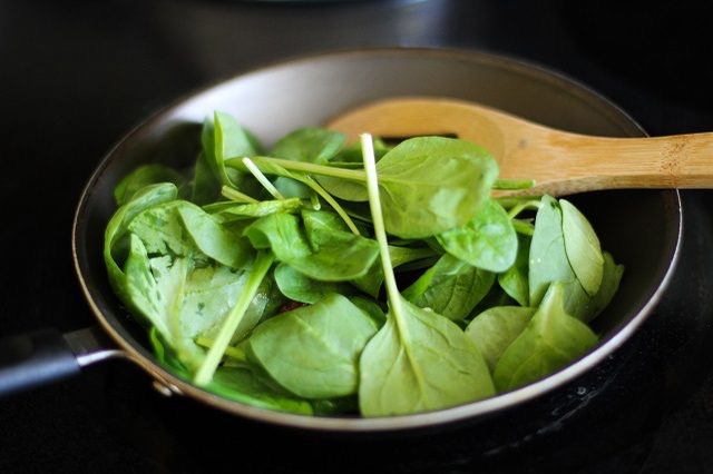 Step 4. Add the baby spinach and chopped basil leaves to the skillet. It's OK if the skillet seems very full -- the leaves will wilt and cook down. Stir occasionally until the leaves have completely wilted, about 3 minutes.