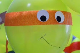 Use green balloons and colored streamers to create the person turtle face