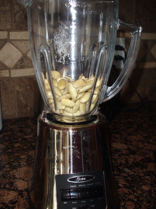 Place almonds in blender on low speed, gradually increase to moderately fast, as it forms scrape the sides to prevent build up .
Add oil one teaspoon to blend at a time.
Store it in room temp for 1-2 weeks to allow oil to separate from nut meat.
You can either strain the nut meat or use oil as is.