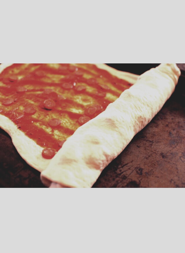 Then proceed to roll the dough up. Once rolled, cut it into 1 inch pieces doing your best to keep all the fillings inside.