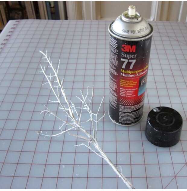 Spray the branch with spray glue/adhesive until it is covert