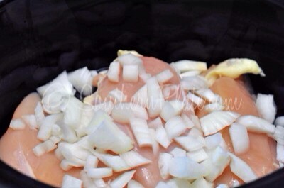Place your chicken breasts in the bottom of your slow cooker. Chop up onion and toss on the top.

