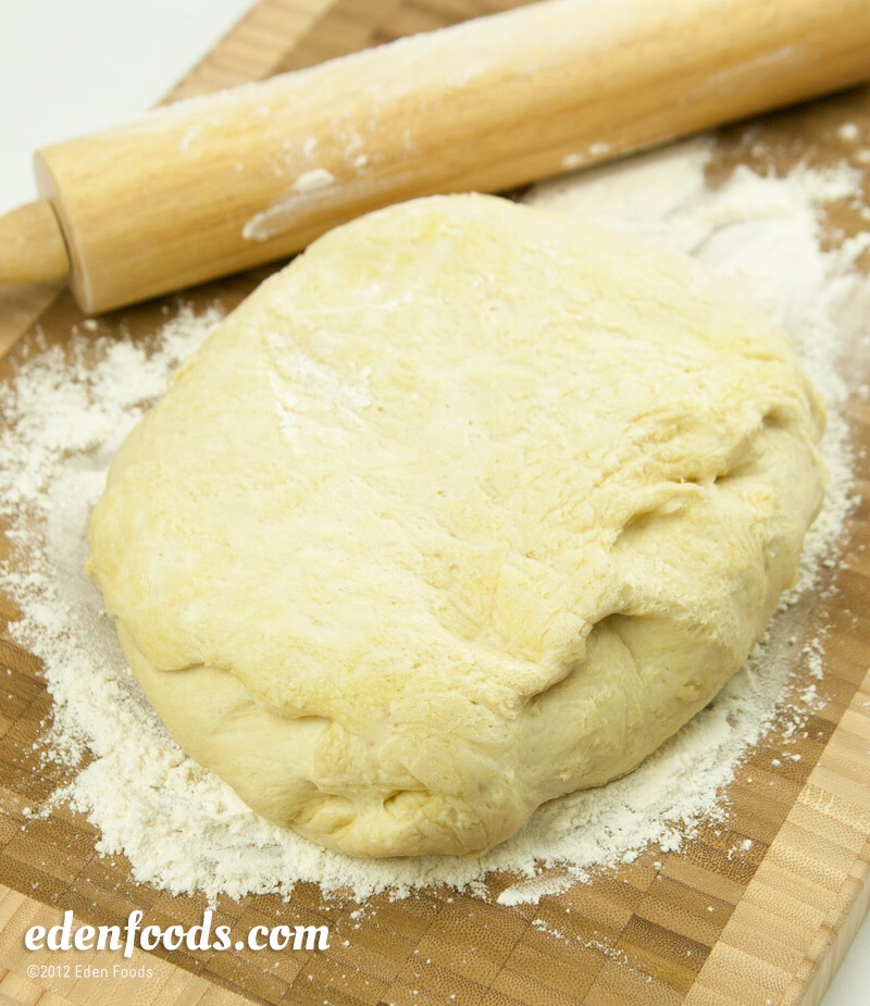 Combine instant dough with the amount of water directed on the package. Roll the dough into a ball and let it sit in a warm area for 15 minutes to allow dough to rise. When it has fully risen, roll it out onto a cutting board or other flat surface.