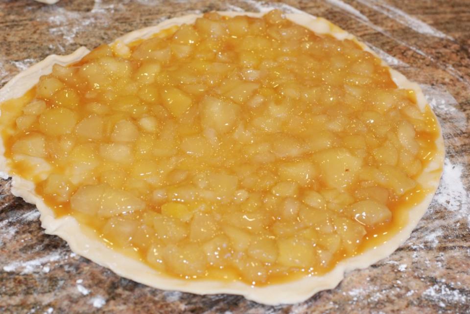 Instructions
Unroll one of the pie crusts and lay it out on your surface.
Spread the Caramel Sauce over the pie crust leaving about ⅛” of an edge
Coarsely chop the apples in the pie filling, then spread on top of the caramel sauce.