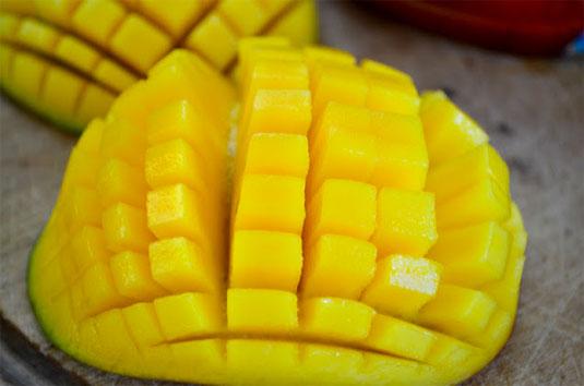 12. Dice a mango quickly by keeping it on the skin instead of peeling it first. Slice off the sides of the fruit, cut the flesh of the mango into a grid right in the skin, then flip it inside out and slice everything off the skin.