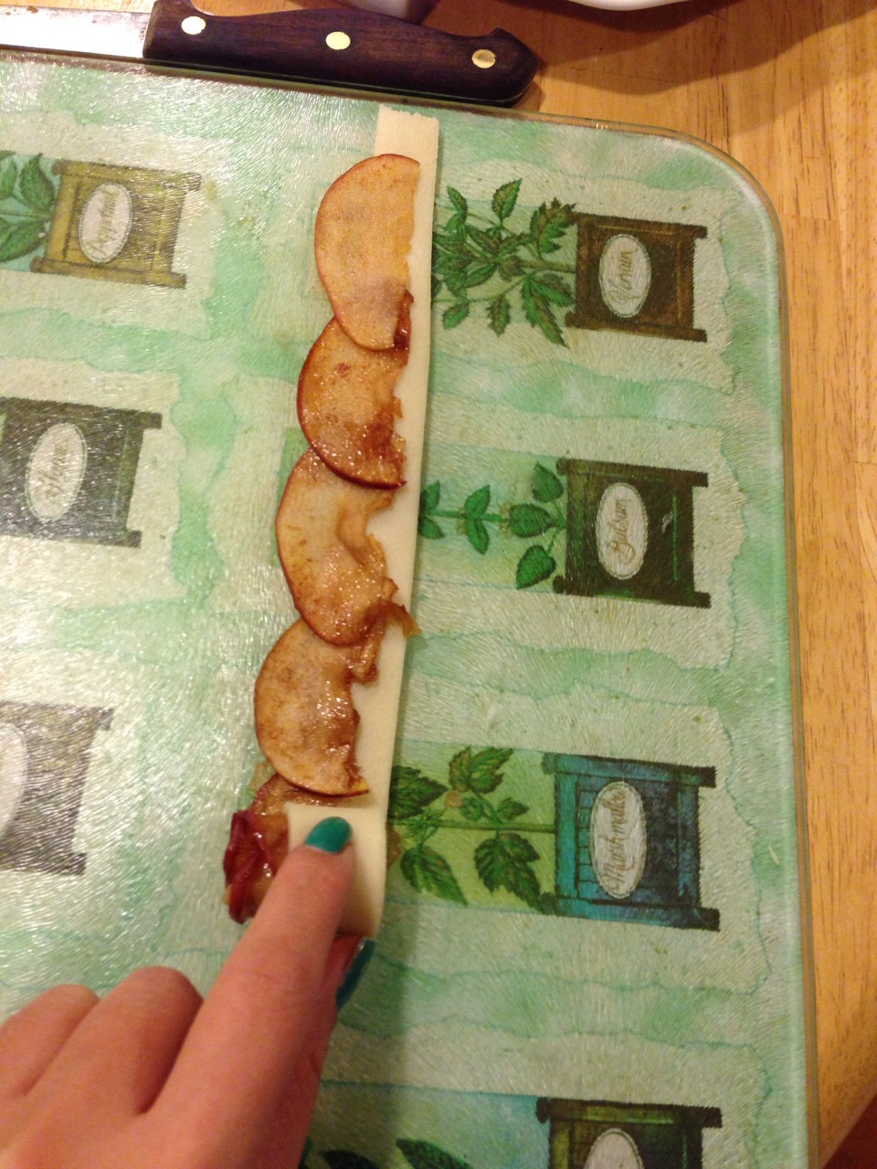 Staring from the same end you behaving laying out the slices, roll up the dough. 
Took me a while to figure it out. You want to roll the dough loosely and keep it the same width throughout, do not tighten the bottom. 