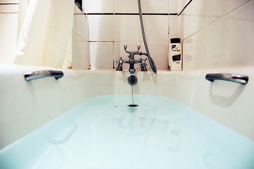 Fill a bath with warm water. Add 1 cup of coffee grounds. Stir the bath. Soak in the water. The longer you soak, the darker your skin will become. Alternatively, rub wet coffee grounds over the skin you wish to darken and let sit for 30 minutes.