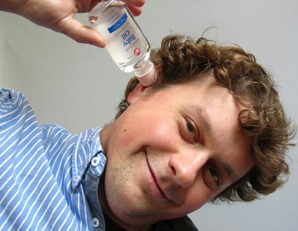 Remove ear wax while laying on your side or tilting your head drop 5 drops of baby oil in  your affected ear (s) leave for 5/10mins then rince outwith warm water and dry.