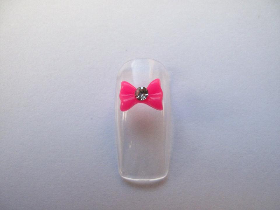 Glue them on artificial nails or natural nails after applying a base coat. If you have some acrylic handy, paint a light layer over the bow to make it really stay put.