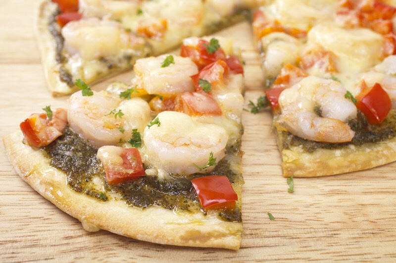 22. Cajun Shrimp Stretch dough into two thin 9-inch rounds. Mix 3/4 cup tomato sauce and 1 tablespoon Cajun seasoning; spread over dough rounds and top with 1 cup shredded manchego. Bake until golden. Saute scallions, green bell pepper, celery and shrimp; season with red pepper flakes. 
