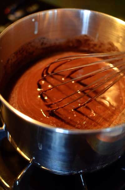 After about 10 minutes, return the chocolate mixture to low heat to completely melt the chocolate. Whisk vigorously until the mixture is thick and shiny.

