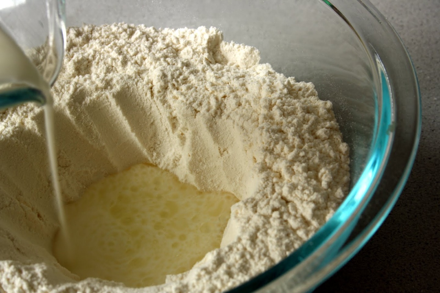 Make a hole in the centre of the flour and pour 1 cup of stirred cream into it. Use broad circles to stir the cream into the flour.  Mix until the dry ingredients are moistened. If there is excess flour, pour a teensy bit more cream in until it's all a wettish consistency. Vice versa if too wet.