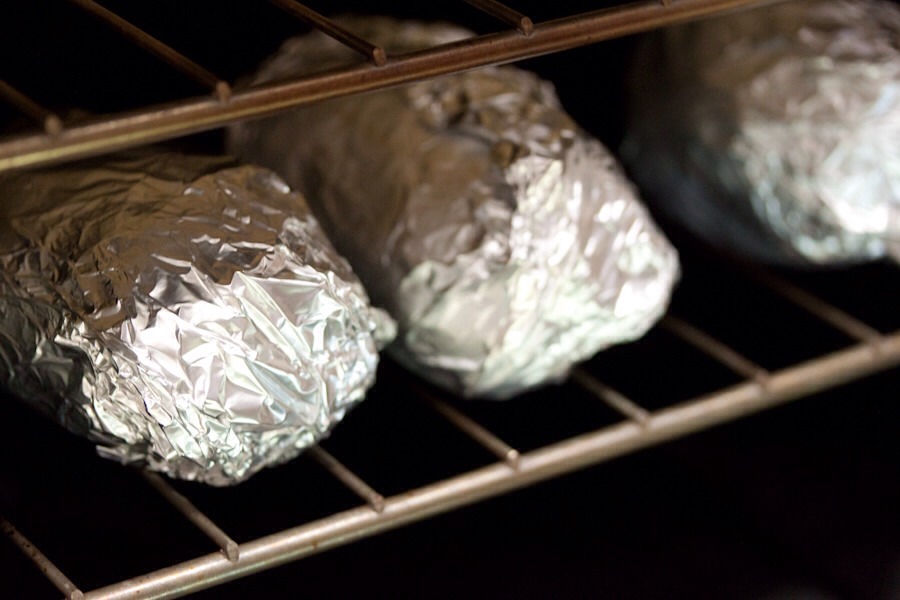 Clean potatoes then wrap in tin foil and put in the oven.