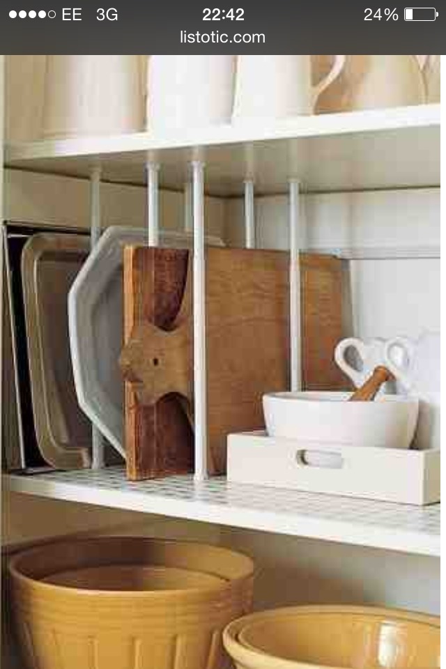 2. Tension rod dividers- Instead of stacking your cutting boards, oven trays, and platters, use those short tension curtain rods to create dividers. Now you can place them upright for easy access and visibility.
