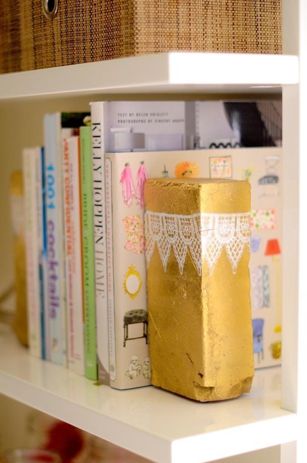 Need bookends? Spray-paint a brick  with gold, then decorate it with trims of lace or other fabric for a glamorous, feminine touch.