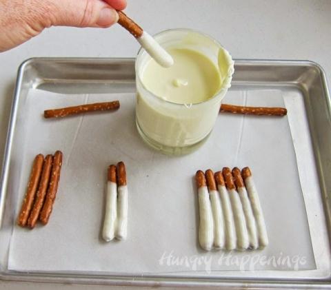 Dip each of the 6 pretzel sticks into the white chocolate. Set them next to each other on a parchment paper lined baking sheet.
Pop in the refrigerator if using pure white chocolate and the freezer if using confectionery coating for 3-5 minutes until the chocolate sets.