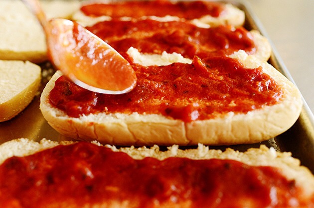 1) Preheat the oven to 375 degrees. Slice rolls in half and lay them, cut side up, on a large baking sheet.

2) Top each half with a generous portion of either pizza sauce or pesto. Next, top with a generous amount of grated mozzarella.