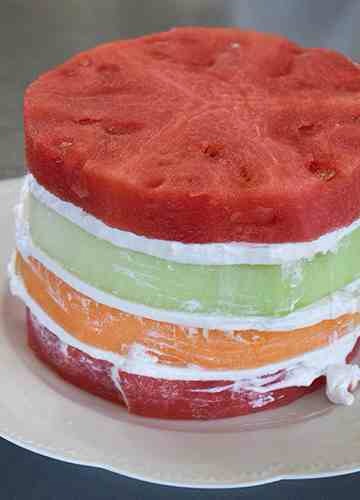 Add another generous layer of frosting. Pat the final slice of watermelon dry and add to the top of the cake.