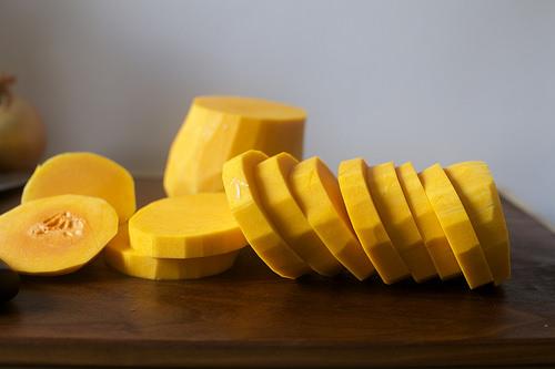 Heat oven to 450. Line large baking sheet with parchment paper. Half, seed and cut your squash into 1/4-inch thick slices. Toss with 3 tablespoons olive oil, 1 to 2 teaspoons salt and chile flakes until evenly coated. 