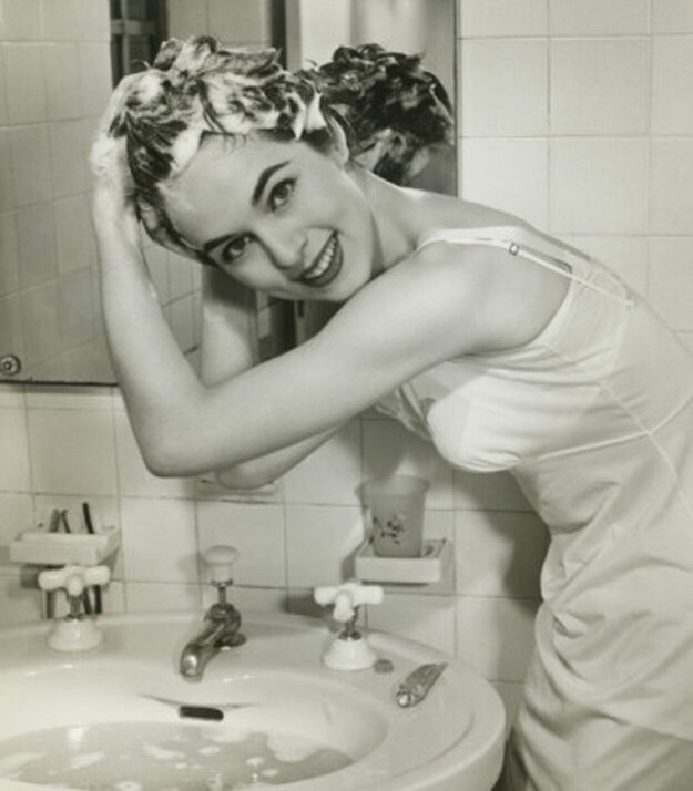 Screw showering: Just wash your roots in the sink.
That's where most of the the dirt and grease collect anyway. And it takes half the time to dry.
(You should still shower this is just a quick fix if you are in a rush!)